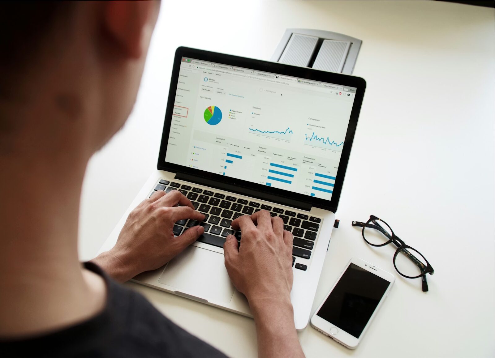 Person using a laptop with code and charts, representing data analysis and probability